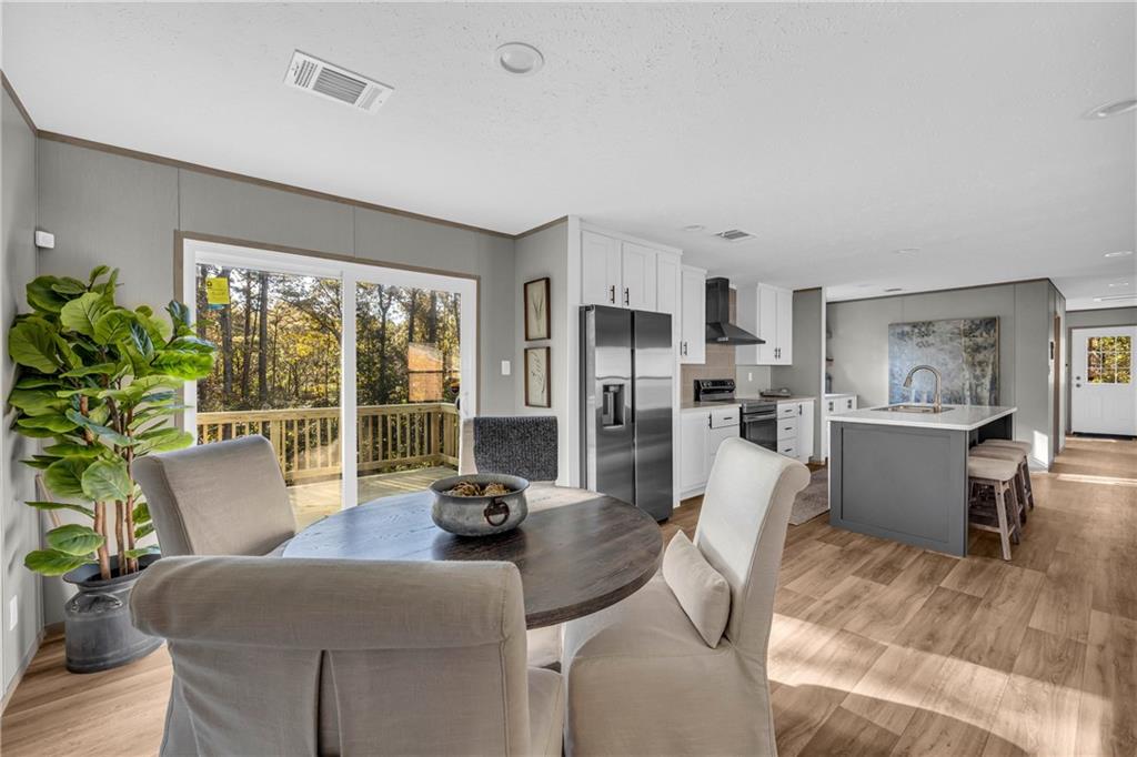 946 Essic Road Ball Ground, GA 30107 - Photo 16 of 45 a kitchen with stainless steel appliances wooden floor dining table and chairs