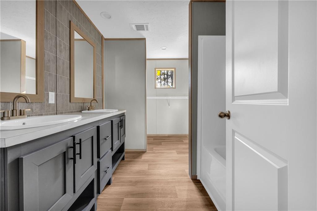 946 Essic Road Ball Ground, GA 30107 - Photo 20 of 45 a bathroom with a double vanity sink and a mirror