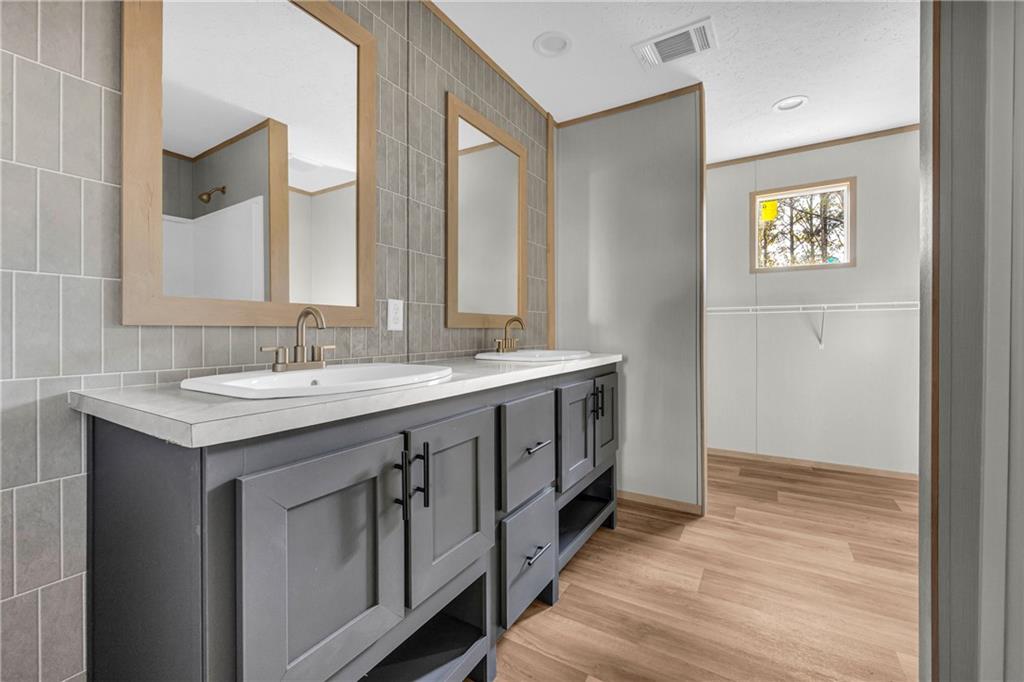 946 Essic Road Ball Ground, GA 30107 - Photo 21 of 45 a spacious bathroom with a double vanity sink and a mirror