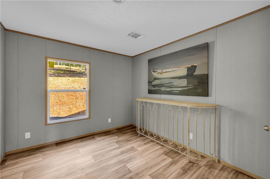 946 Essic Road Ball Ground, GA 30107 - Photo 25 of 45 a view of an empty room with wooden floor and a window