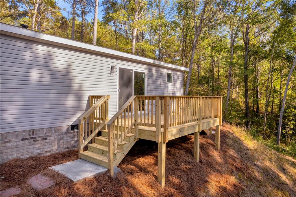 946 Essic Road Ball Ground, GA 30107 - Photo 40 of 45 a view of a house with a wooden deck and furniture