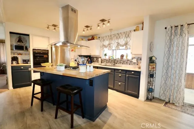 a kitchen with stainless steel appliances granite countertop a sink a stove and refrigerator