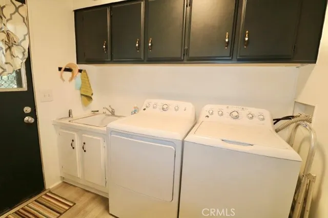 a living room with couches kitchen view and kitchen view with wooden floor