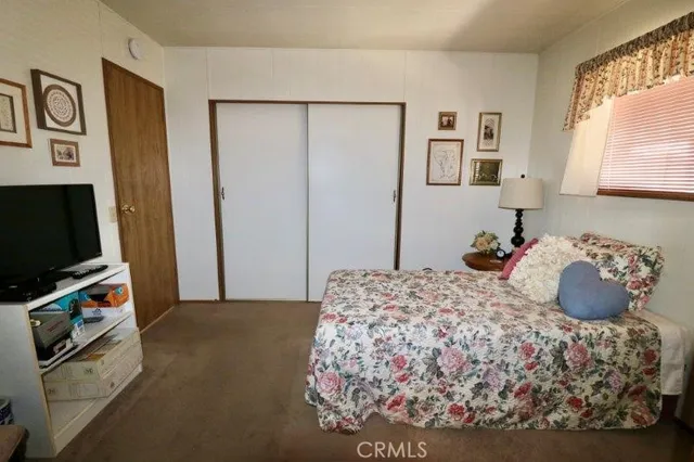 a bedroom with a bed and a television