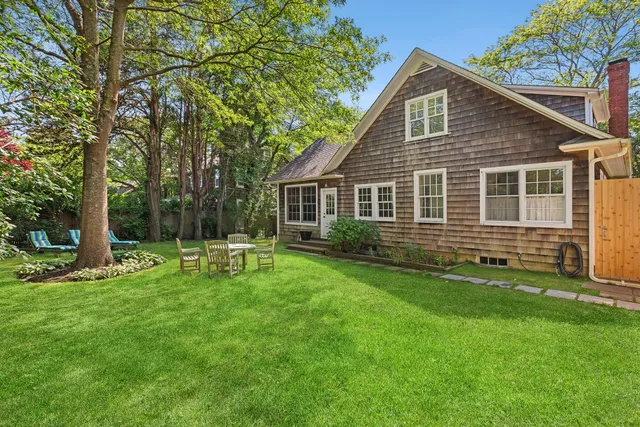 a front view of a house with a garden and trees