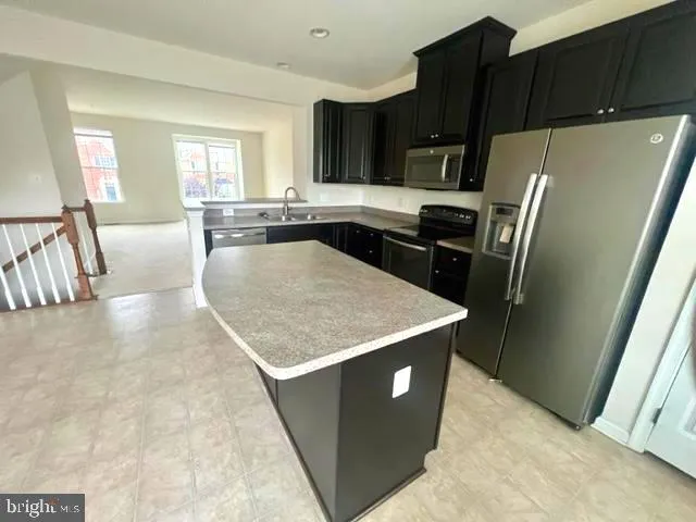 a kitchen with granite countertop a refrigerator and a sink