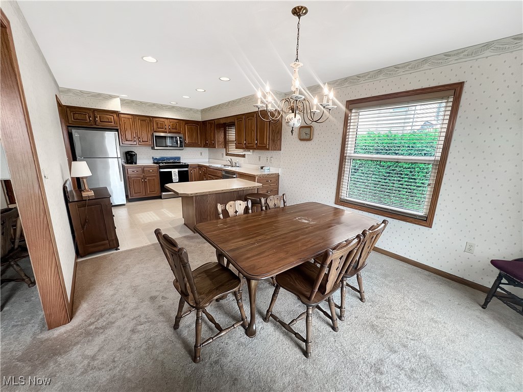 3801 Hull Road Huron, OH 44839 - Photo 3 of 24 Dining space featuring a chandelier, wallpapered walls, recessed lighting, and light carpet