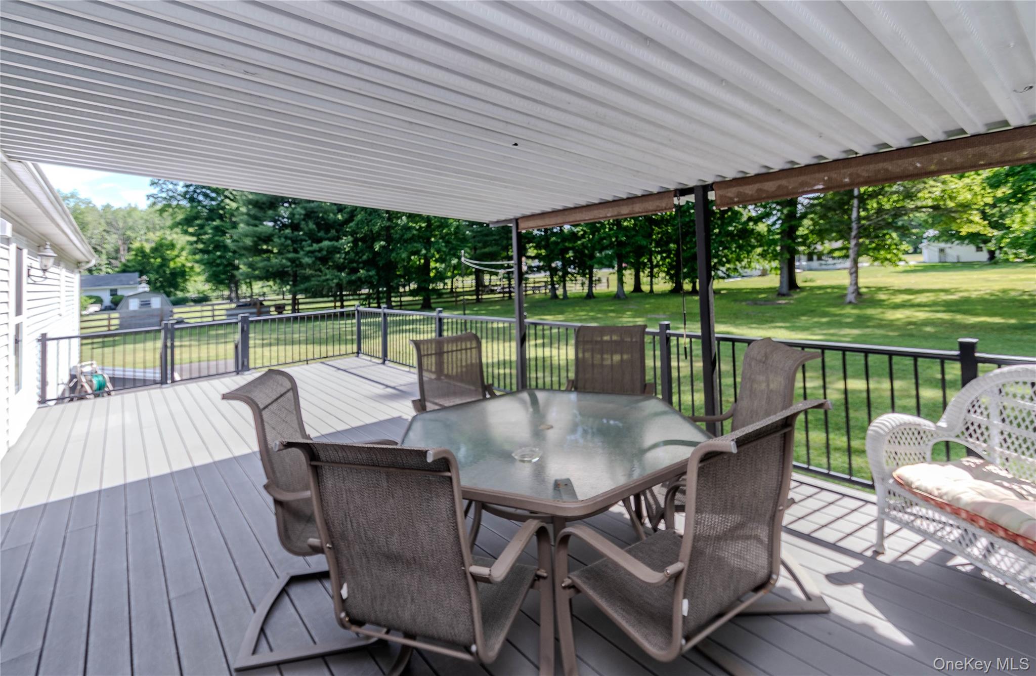 15 Van Dewark Road Middletown, NY 10941 - Photo 22 of 41 Covered outdoor deck with composite decking and black metal railings, featuring a white vinyl soffit ceiling