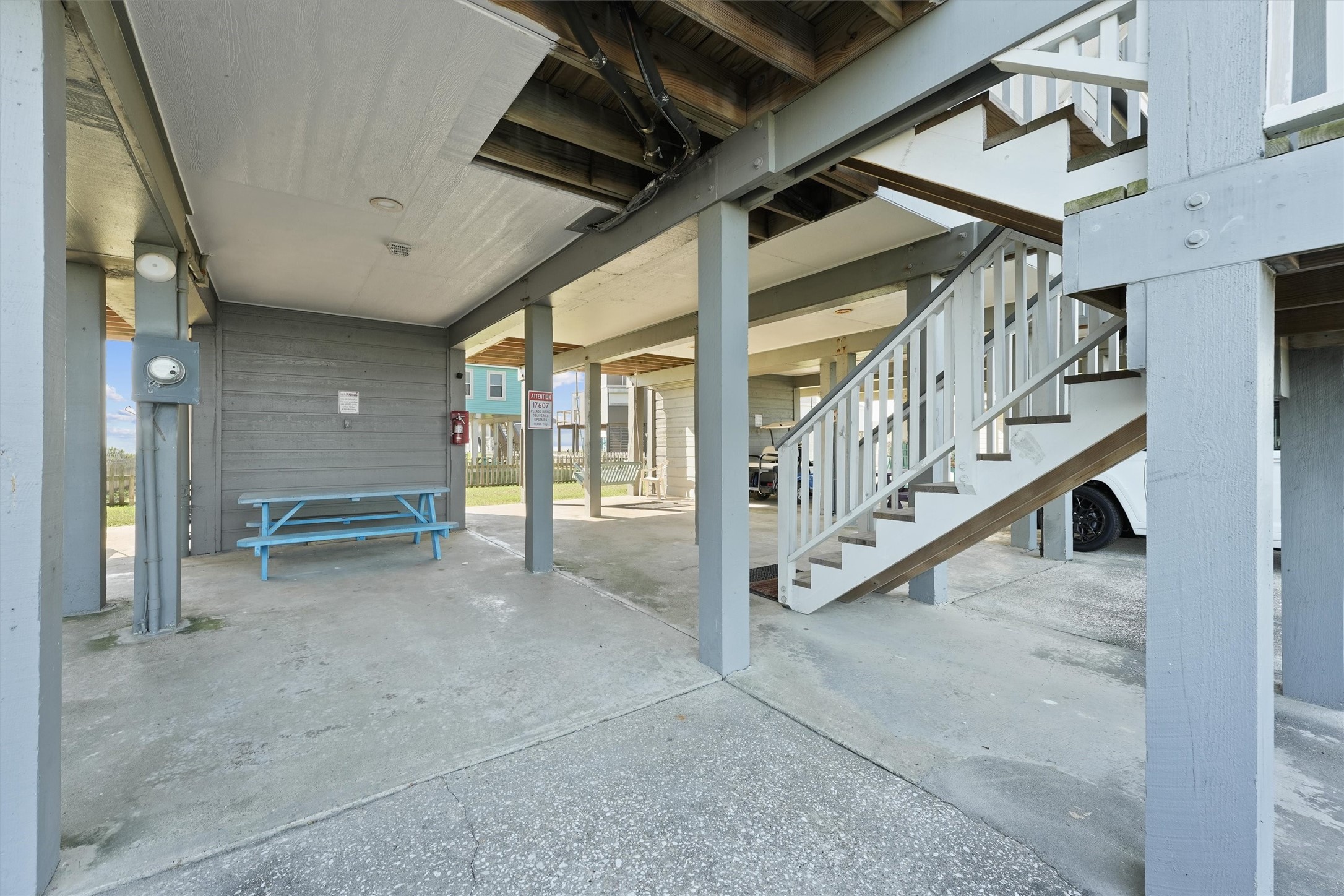 17607 Termini-San Luis Pass Road Galveston, TX 77554 - Photo 34 of 42 The ground level features a spacious covered area perfect for storing outdoor gear or enjoying a shaded afternoon. The staircase leads up to the main living area, providing easy access while preserving the coastal charm.