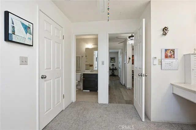 a view of a hallway with closet and a bathroom