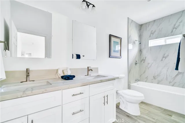 a bathroom with a granite countertop sink a toilet and a bathtub