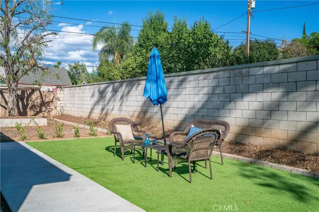 a view of a chair and table in backyard of the house