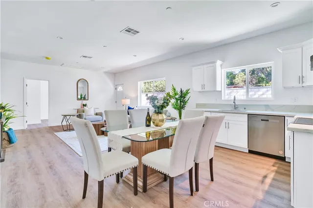 a dining room with furniture and potted plants