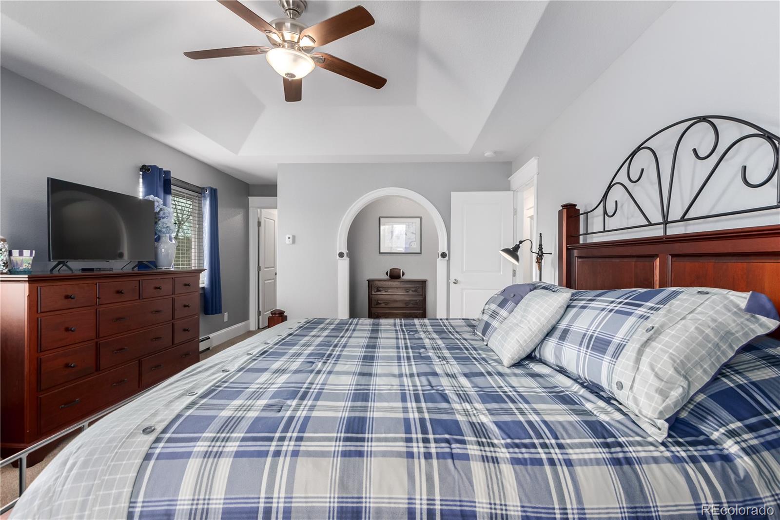 10640 West 46th Avenue Wheat Ridge, CO 80033 - Photo 14 of 46 a bedroom with a large bed and a flat tv screen on dresser