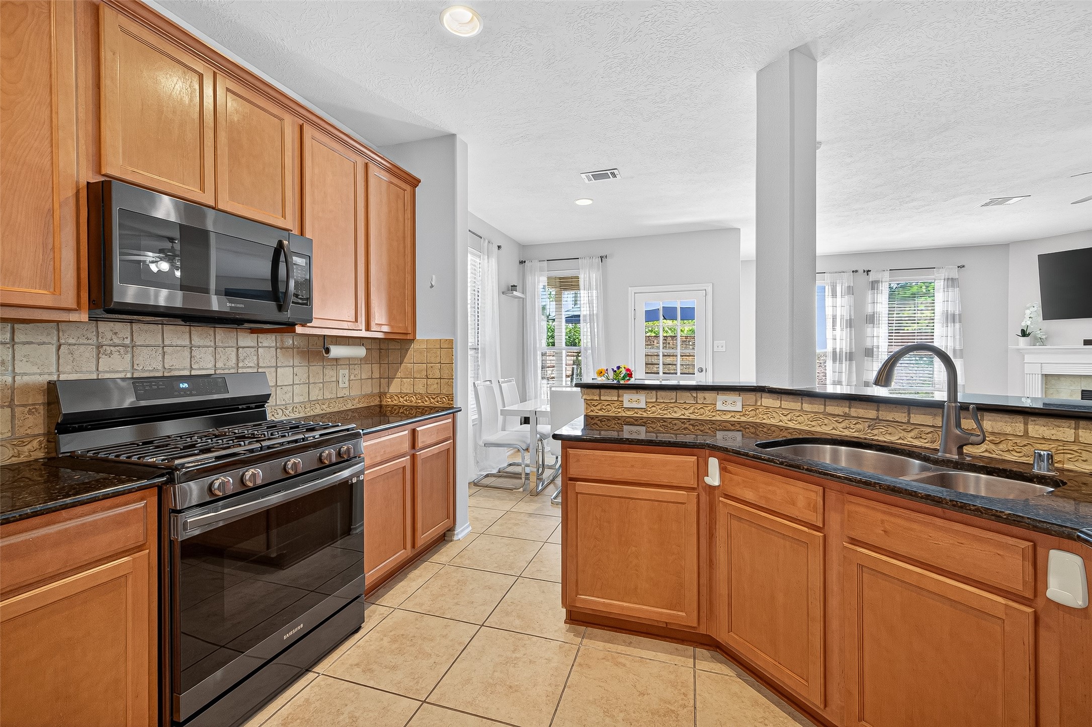 6230 Hollydale Ridge Lane Katy, TX 77494 - Photo 14 of 41 a kitchen with stainless steel appliances a stove sink microwave and cabinets