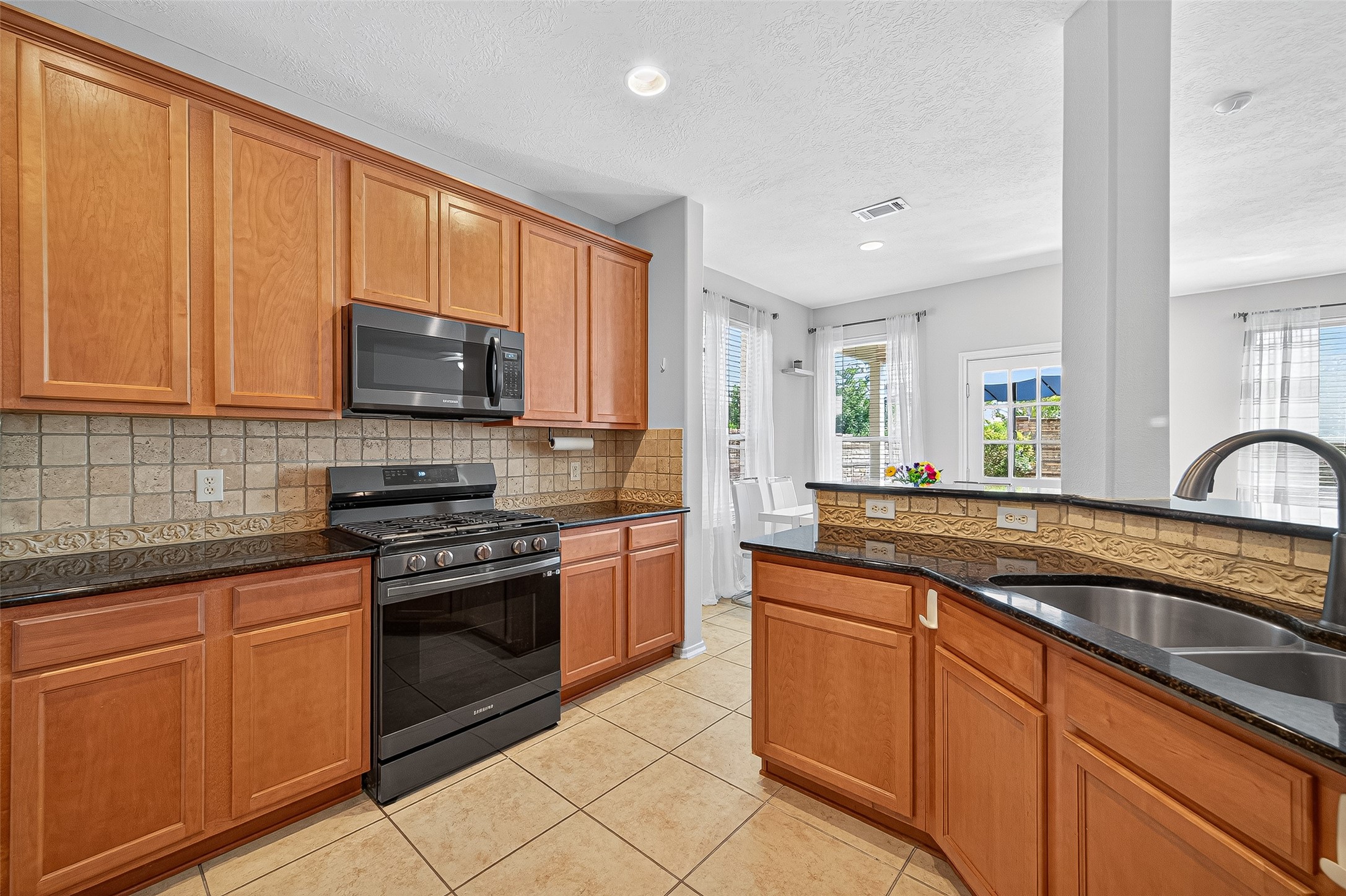 6230 Hollydale Ridge Lane Katy, TX 77494 - Photo 10 of 41 a kitchen with stainless steel appliances granite countertop a sink stove and microwave