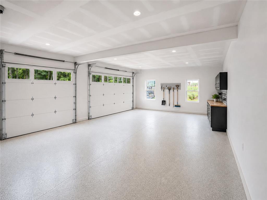 3104 Moyer Road Hellertown, PA 18055 - Photo 23 of 30 A spacious garage boasts immaculate epoxy flooring, recessed lighting, and built-in workspace cabinetry.
