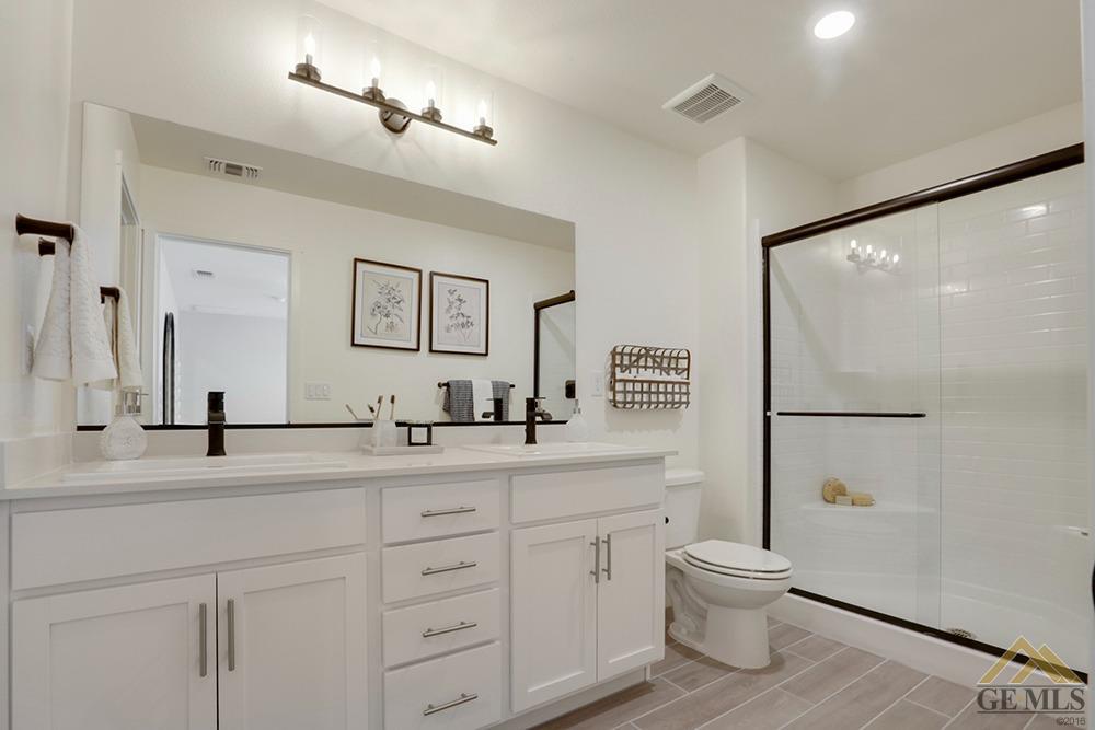 Undisclosed Address Bakersfield, CA 93311 - Photo 18 of 28 a bathroom with a granite countertop sink mirror vanity and toilet