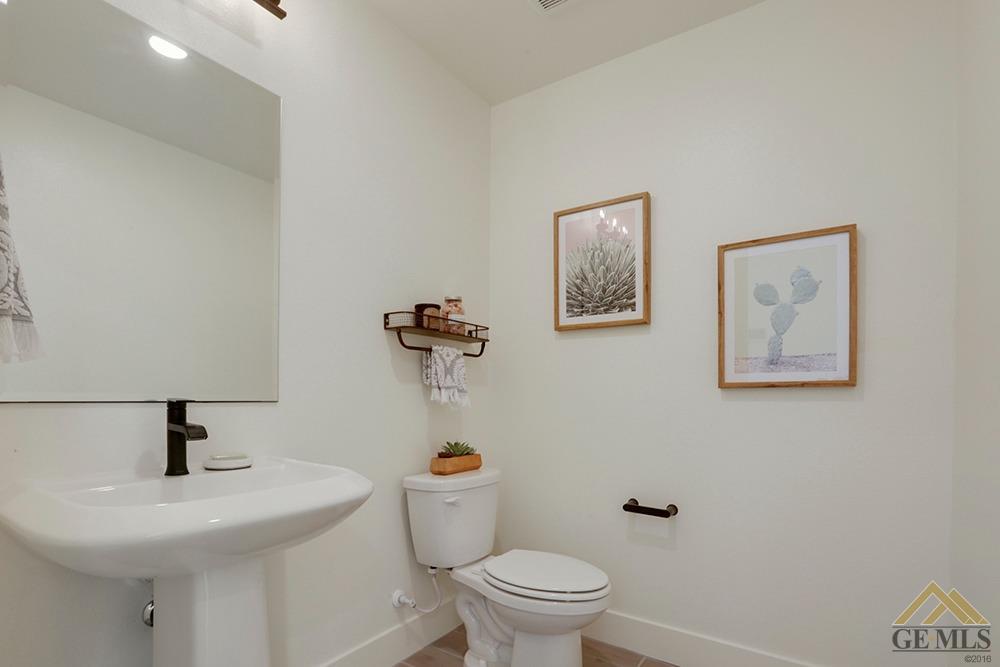 Undisclosed Address Bakersfield, CA 93311 - Photo 26 of 28 a bathroom with a toilet a sink and mirror
