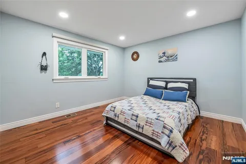 a bedroom with a bed and wooden floor