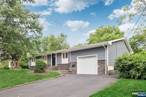 a view of a house with a yard and potted plants