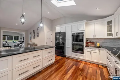 a kitchen with stainless steel appliances kitchen island granite countertop a refrigerator and a stove top oven