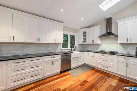 a kitchen with granite countertop white cabinets and white appliances