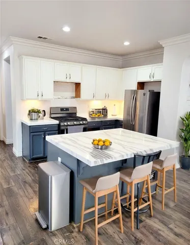 a kitchen with stainless steel appliances granite countertop a table chairs sink refrigerator and microwave