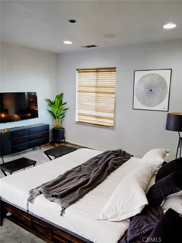 a bedroom with a bed and a flat screen tv