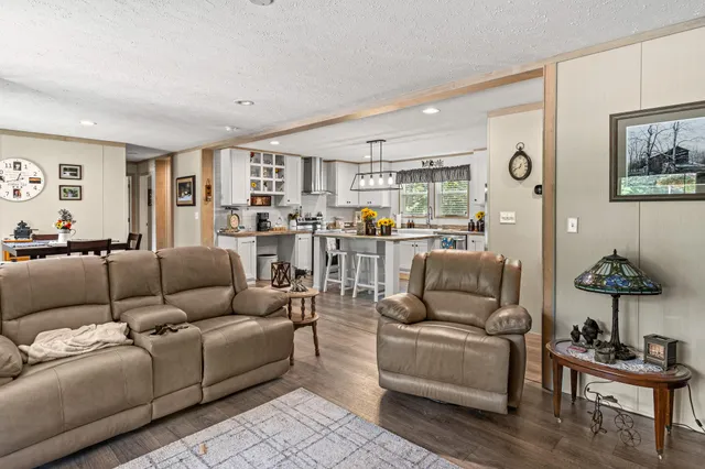 a living room with furniture and view of kitchen