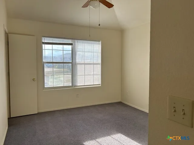 an empty room with chandelier fan