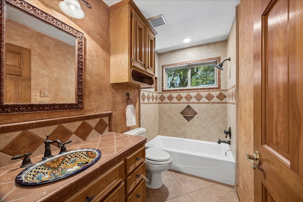 1835 Raintree Circle Seabrook, TX 77586 - Photo 16 of 50 a bathroom with a granite countertop bathtub sink vanity mirror and toilet