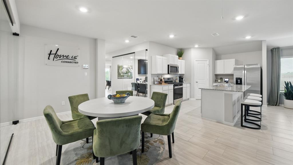 1645 Tin Roof Road Krum, TX 76249 - Photo 8 of 36 a view of a dining room with furniture and wooden floor