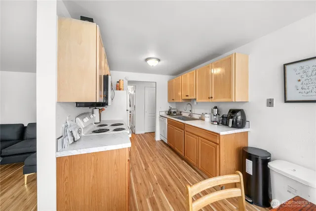 a large kitchen with granite countertop a sink stainless steel appliances and cabinets