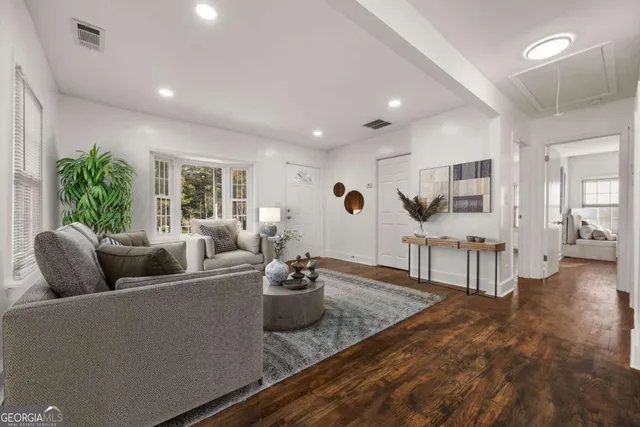 a living room with furniture and a wooden floor