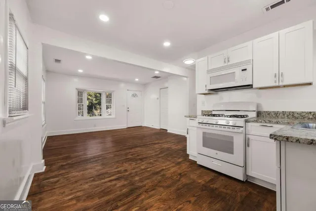 a kitchen with stainless steel appliances granite countertop a stove and a refrigerator