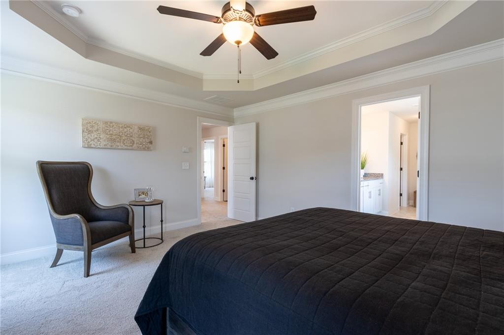 560 Calgary Downs Drive Winder, GA 30680 - Photo 24 of 37 a bedroom with a bed and a chandelier