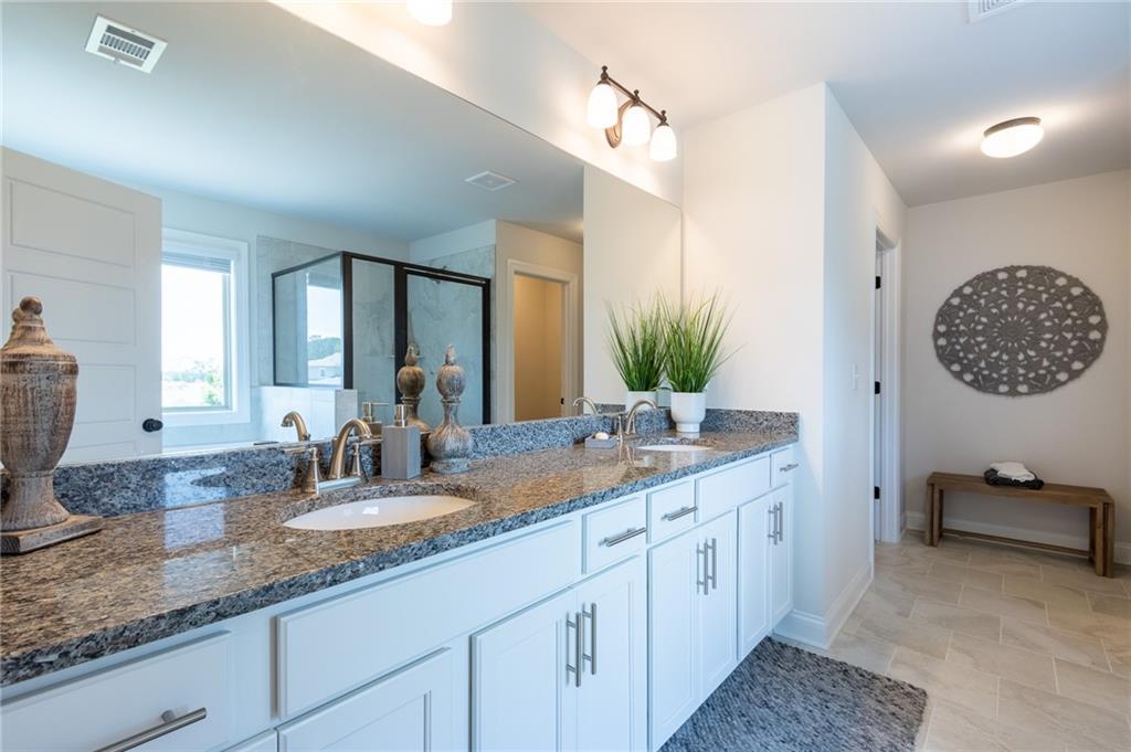 560 Calgary Downs Drive Winder, GA 30680 - Photo 25 of 37 a bathroom with a granite countertop double vanity sink and a mirror