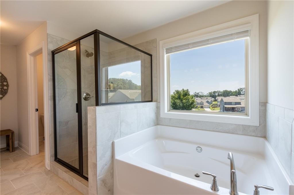 560 Calgary Downs Drive Winder, GA 30680 - Photo 27 of 37 a bathroom with a bathtub and a shower