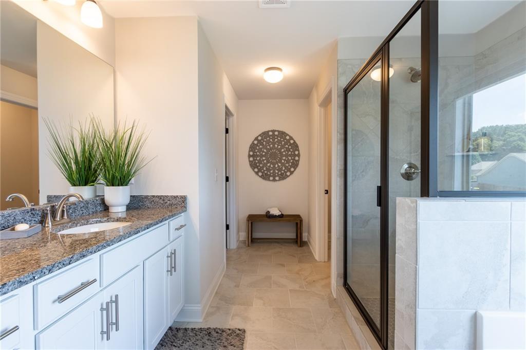 560 Calgary Downs Drive Winder, GA 30680 - Photo 28 of 37 a spacious bathroom with a granite countertop sink and a mirror