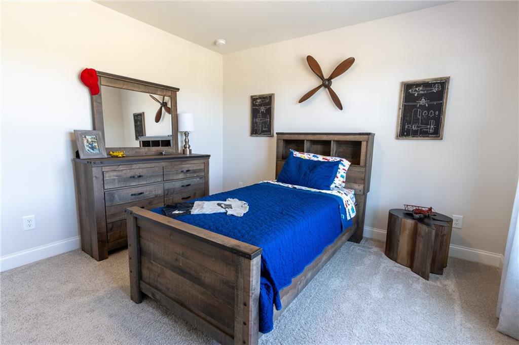 560 Calgary Downs Drive Winder, GA 30680 - Photo 36 of 37 a bedroom with a bed and a chandelier