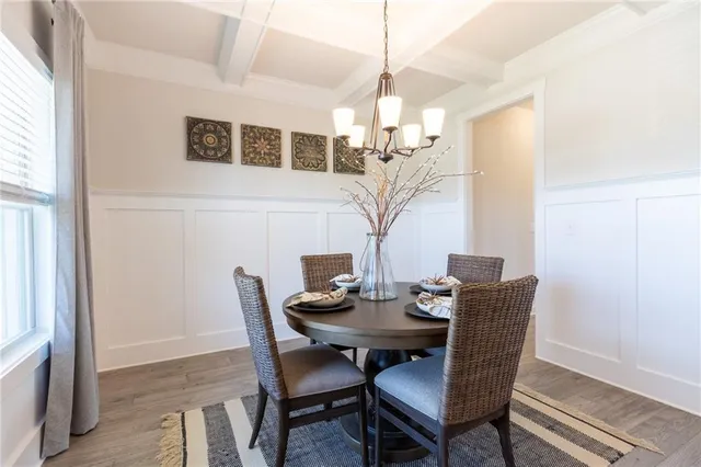 a view of a dining room with furniture a chandelier and wooden floor