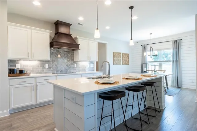 a kitchen with stainless steel appliances granite countertop a sink a stove and a wooden floors