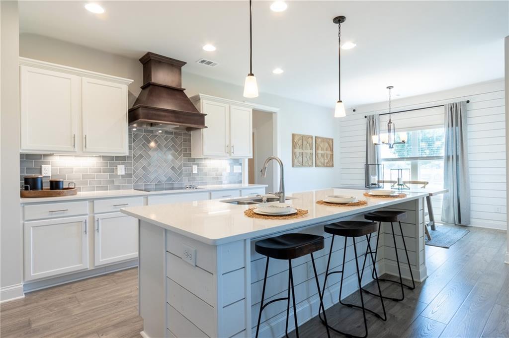 560 Calgary Downs Drive Winder, GA 30680 - Photo 6 of 37 a kitchen with stainless steel appliances granite countertop a sink a stove and a wooden floors