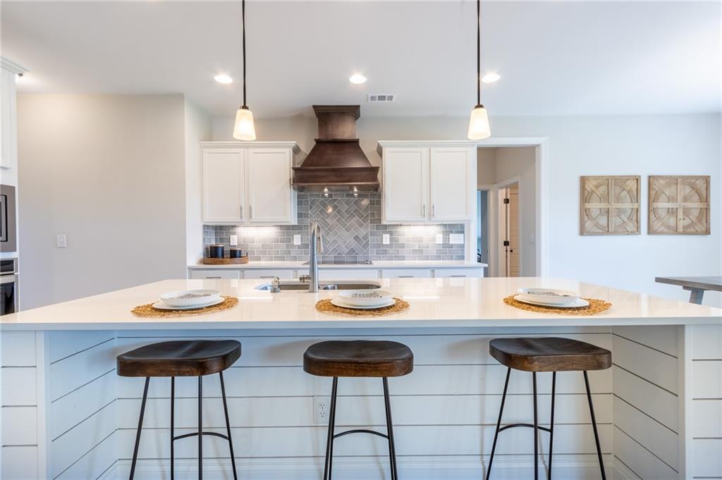 560 Calgary Downs Drive Winder, GA 30680 - Photo 7 of 37 a kitchen with stainless steel appliances kitchen island a table and chairs in it