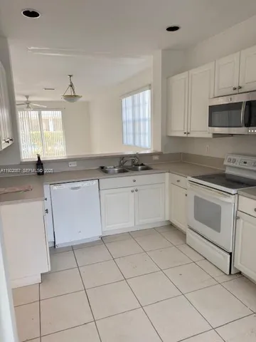 a white kitchen with a stove top oven and sink