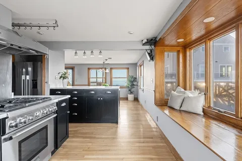 a large kitchen with stainless steel appliances granite countertop a stove and large cabinets