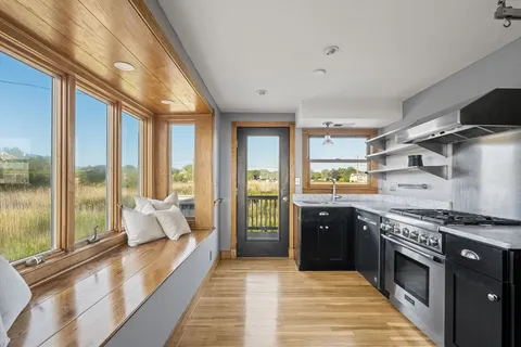 a view of a hallway with wooden floor and cabinets