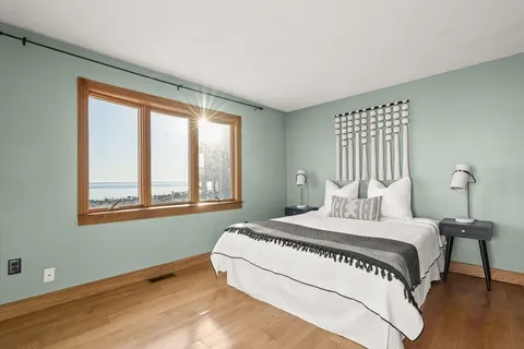 a bedroom with a bed and a large window