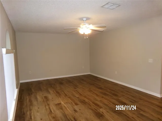a view of a room with wooden floor and a ceiling fan
